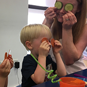 Family laughing with vegetables on face 