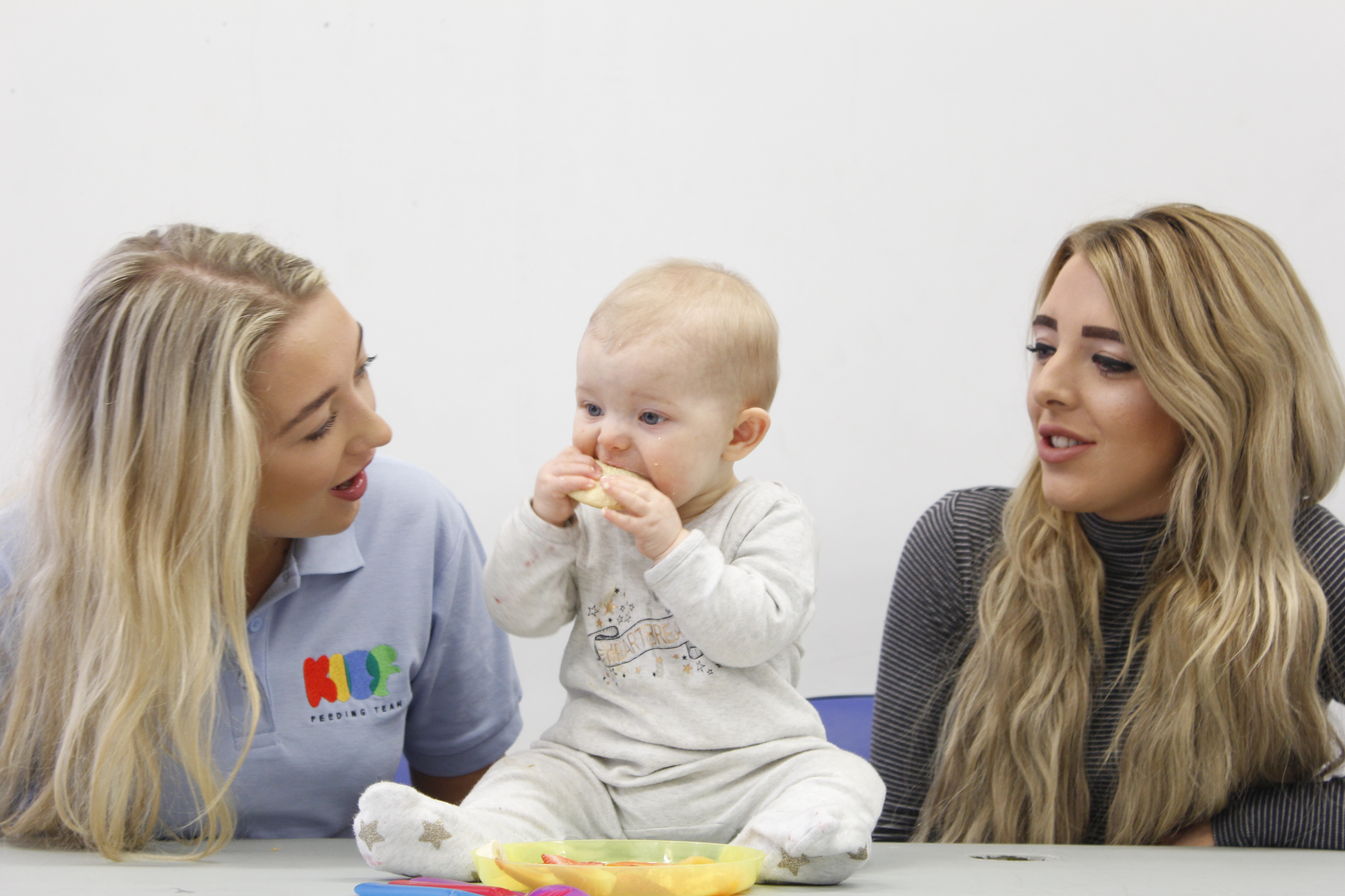 Albie feeding himself with mum and saffron either side